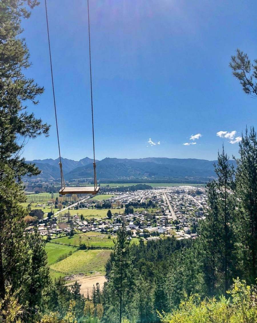 Columpio con vista a un pueblo y cerros